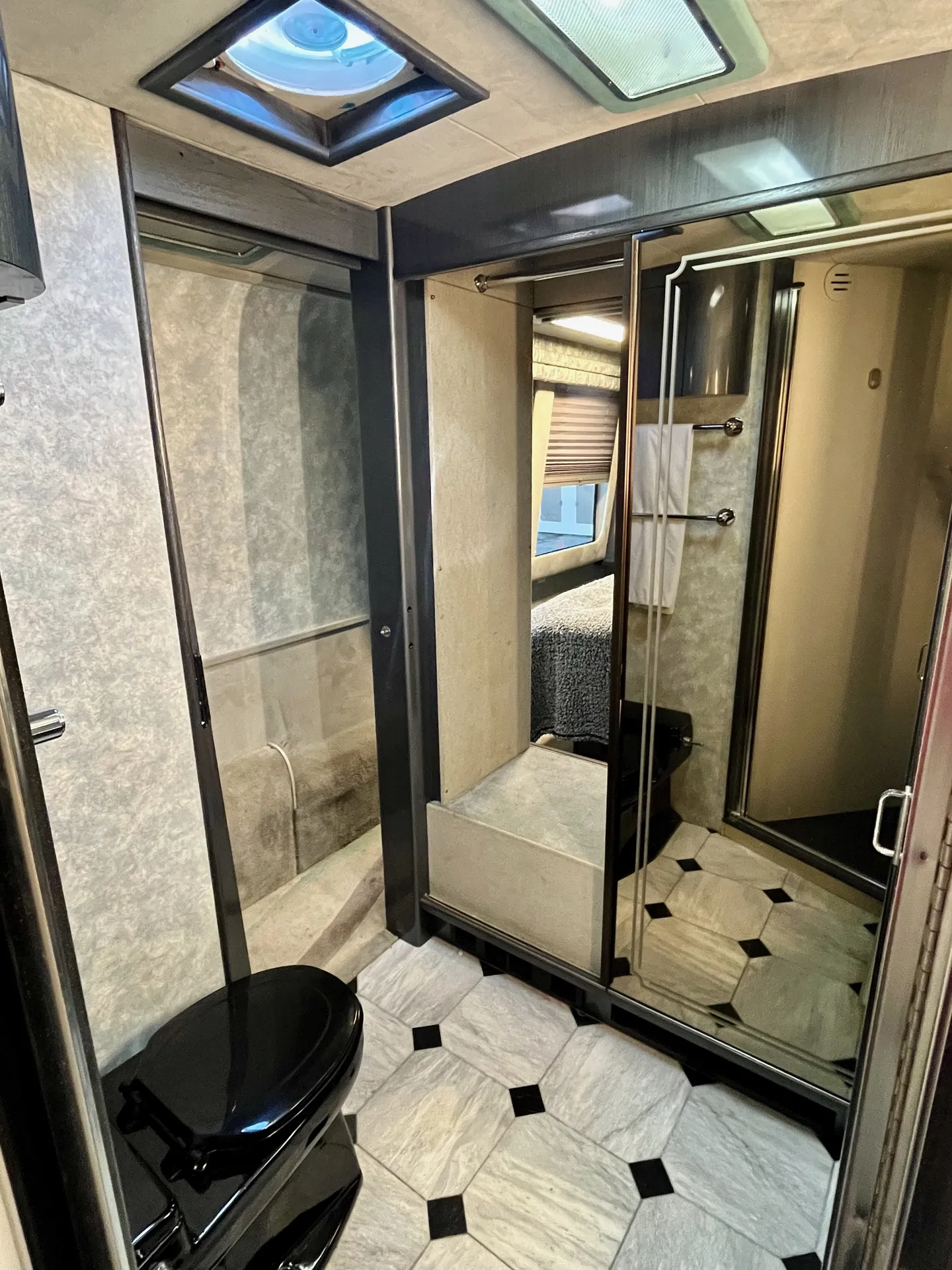 Bathroom with skylight and mirrored wardrobe access