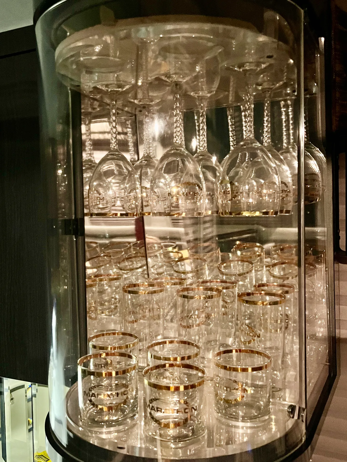 Crystal glassware cabinet with gold-rimmed Marathon glasses